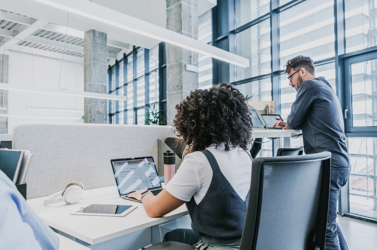Casual guy and girl working on their laptops in an office