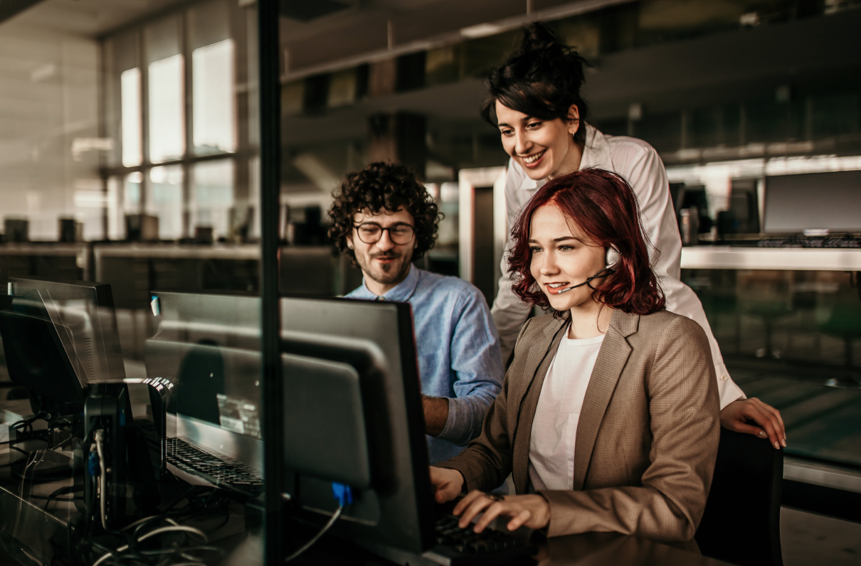 Three colleagues talking around a computer