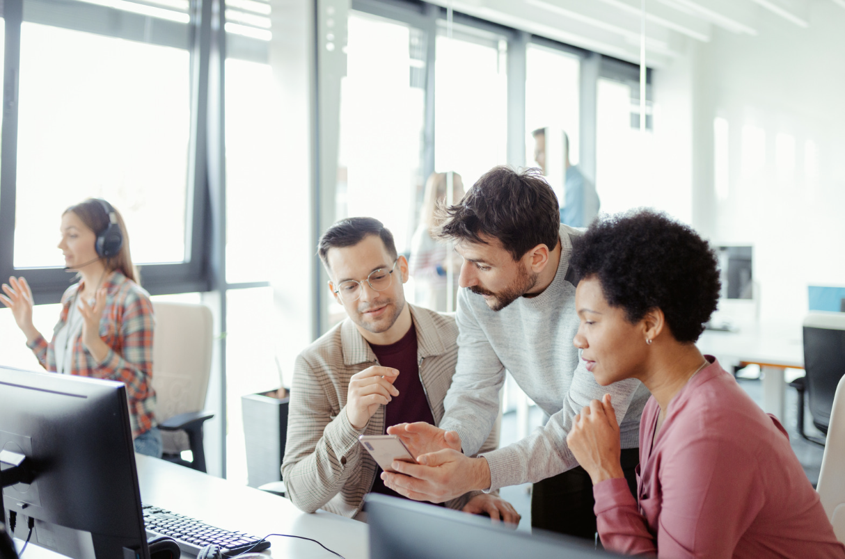 Office group discussing around a computer