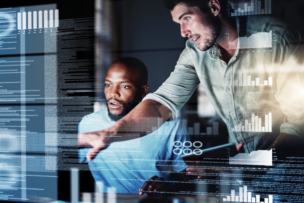 office worker advising colleague infront of computer screen